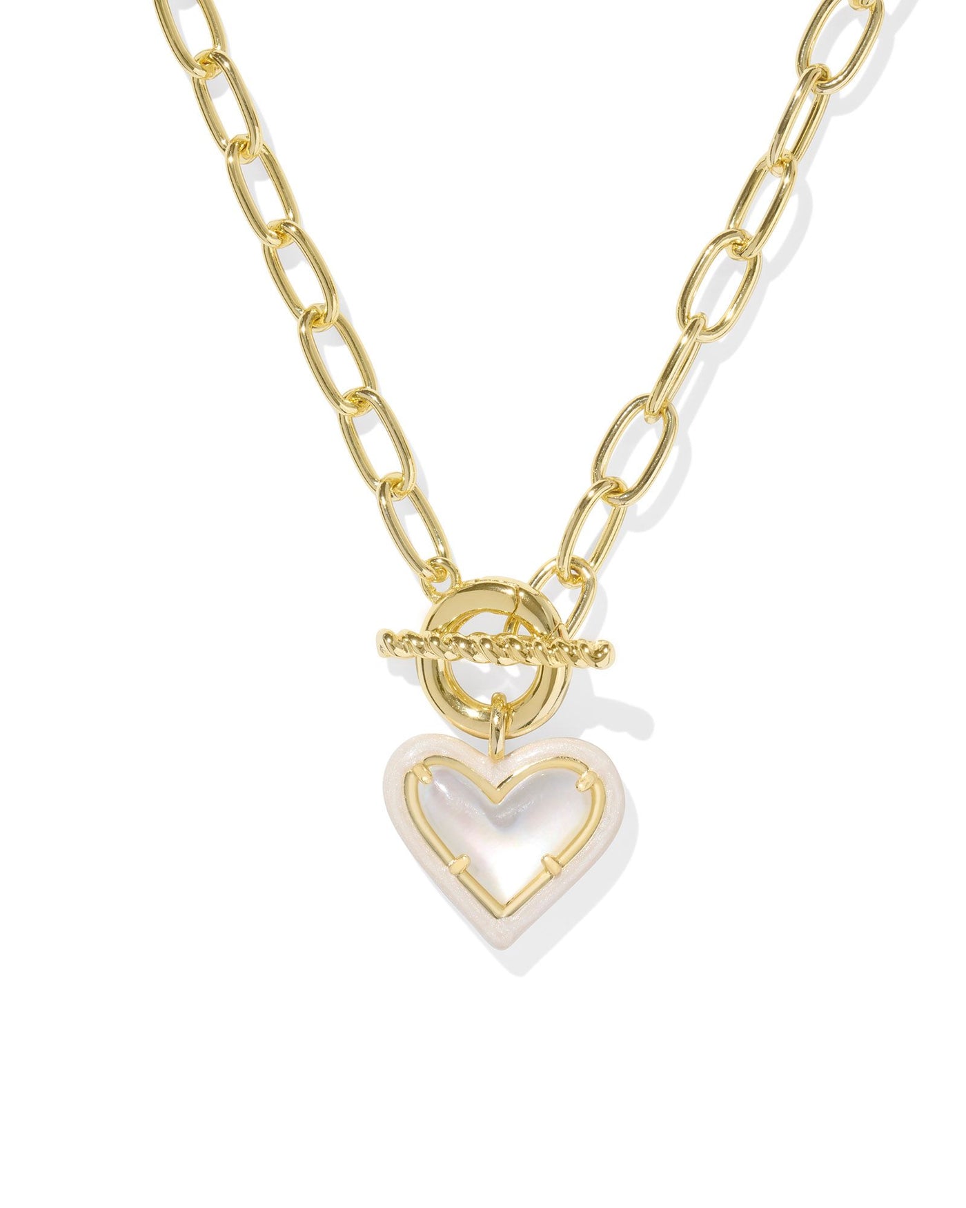 Gold link chain necklace with enamel framed ivory mother of pearl heart pendant, closeup.