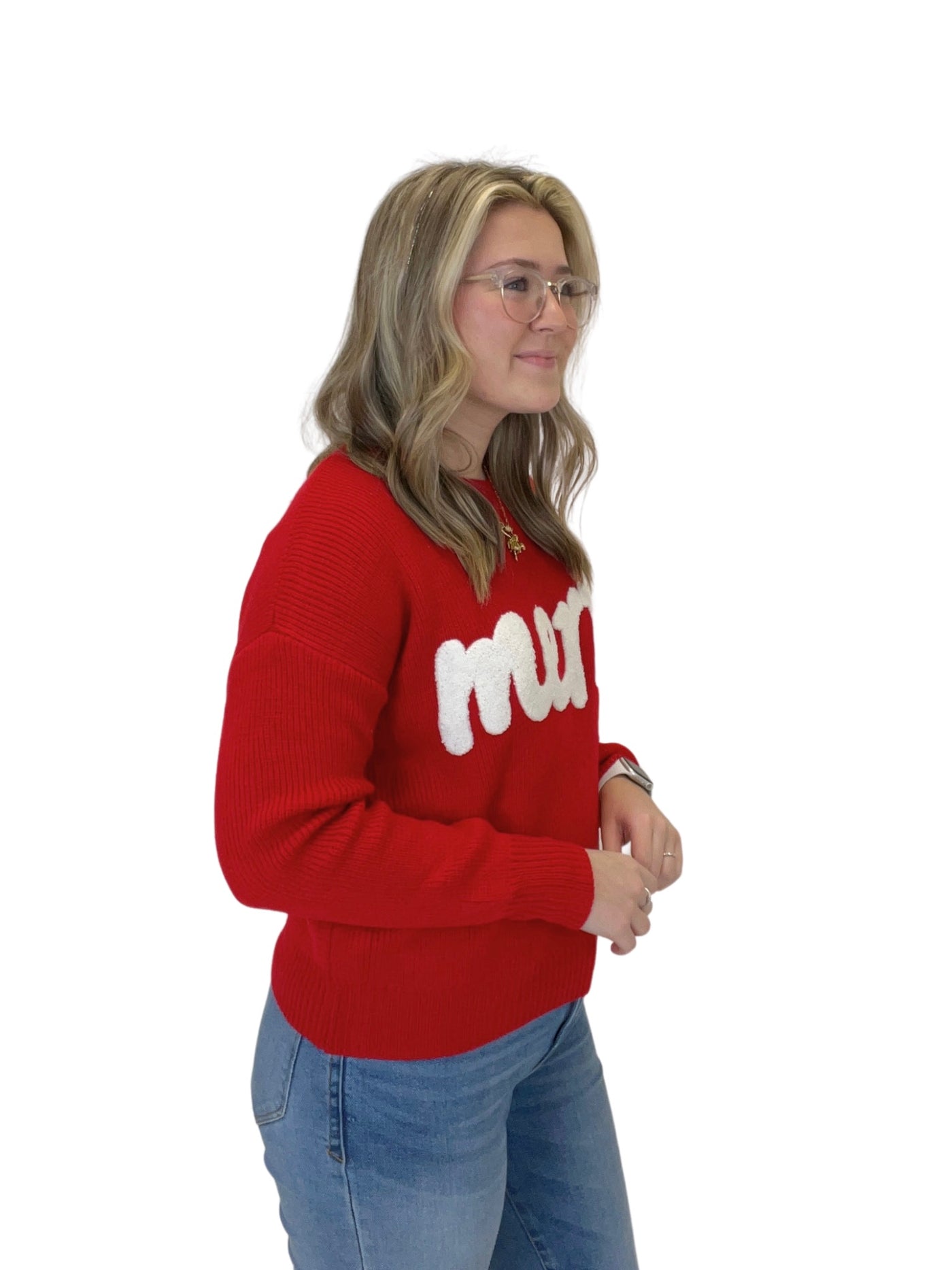 Red "merry" embroidered sweater on model, side view.