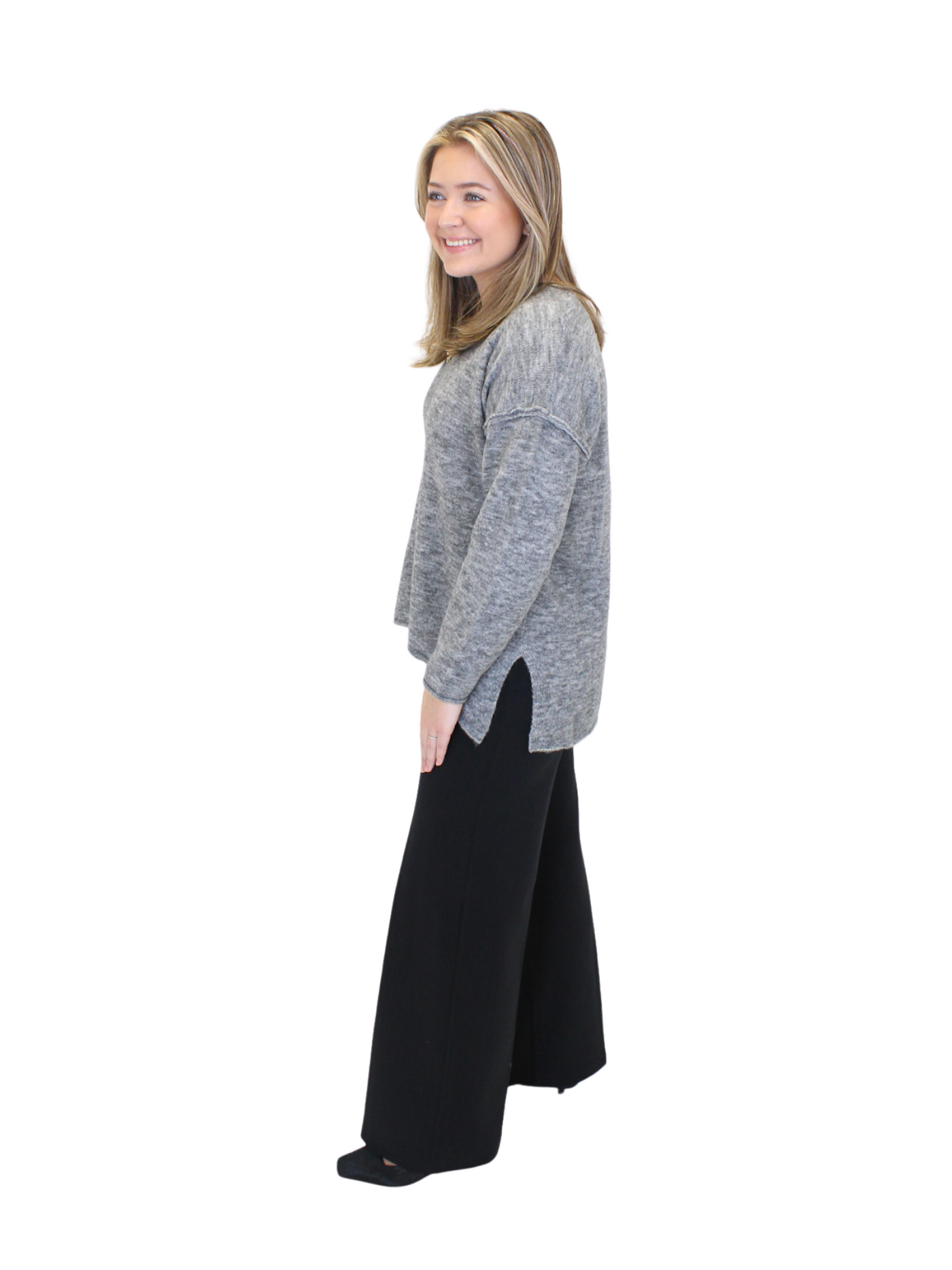 Charcoal gray v-neck sweater with side slits on model, side view.