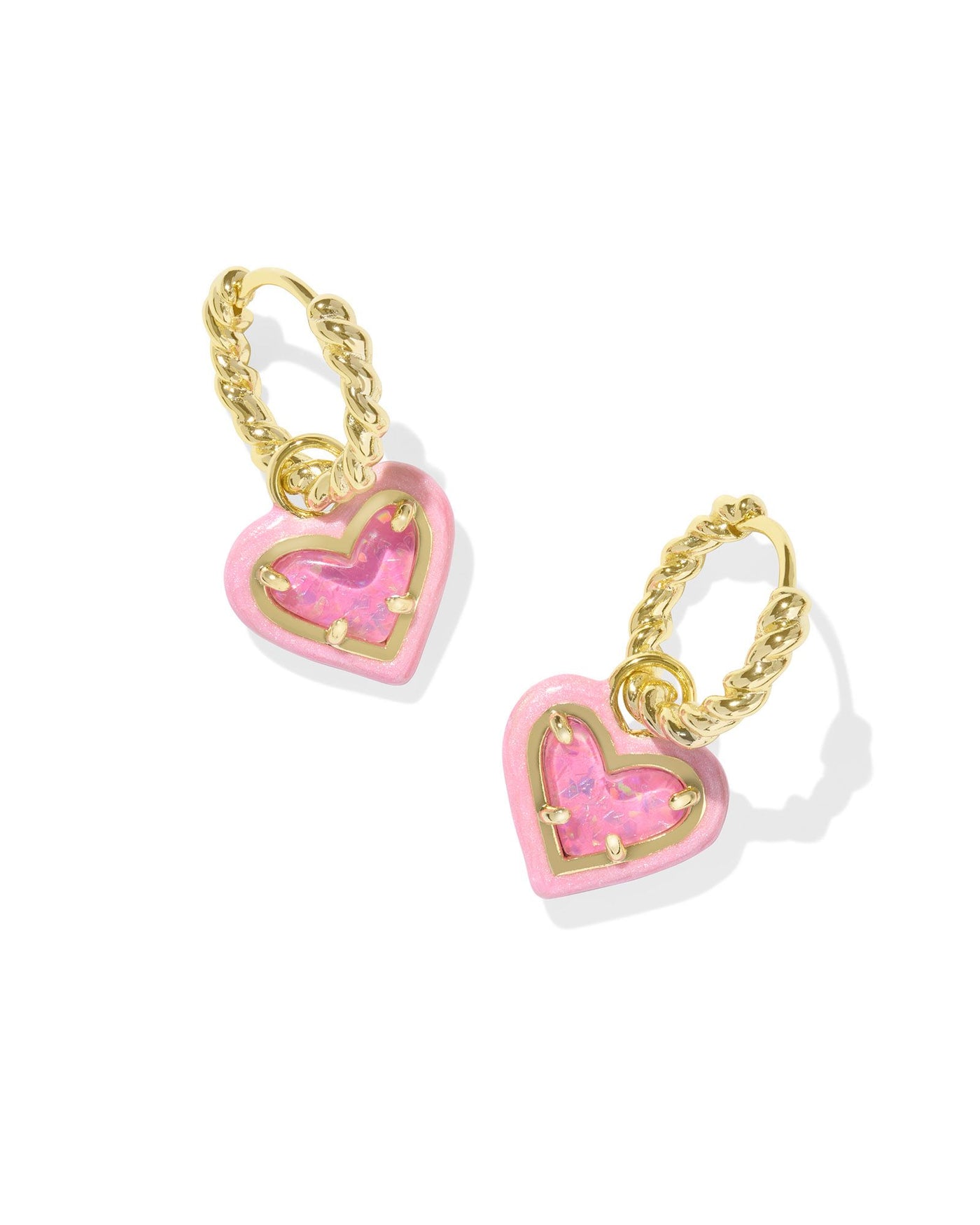 Twisted gold huggie hoop earrings with enamel framed pink glitter heart pendant. 